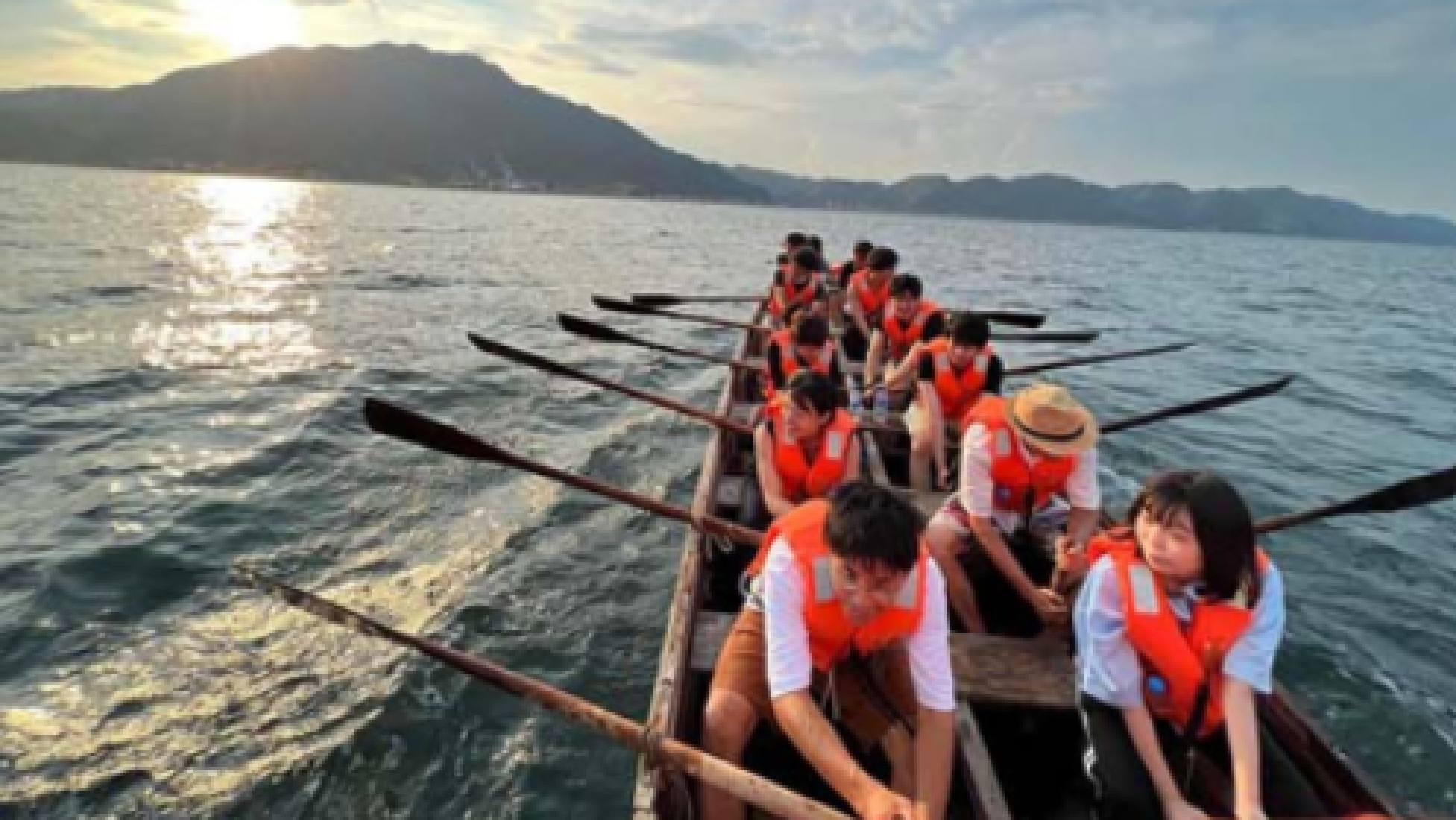 協力してボートを漕いでいる風景