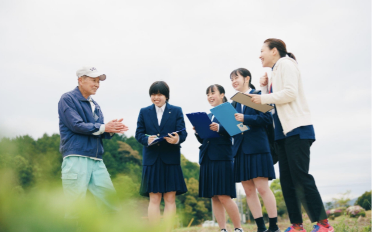 地元の人と高校生たちが笑顔で交流している様子